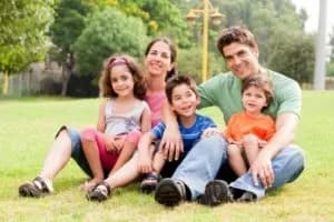Família asseguda a la gespa d'un parc