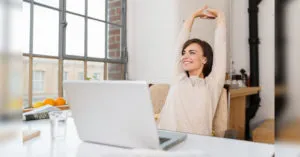 noia a l'oficina estirant els braços