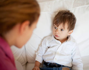 madre hablando con niño en sofa